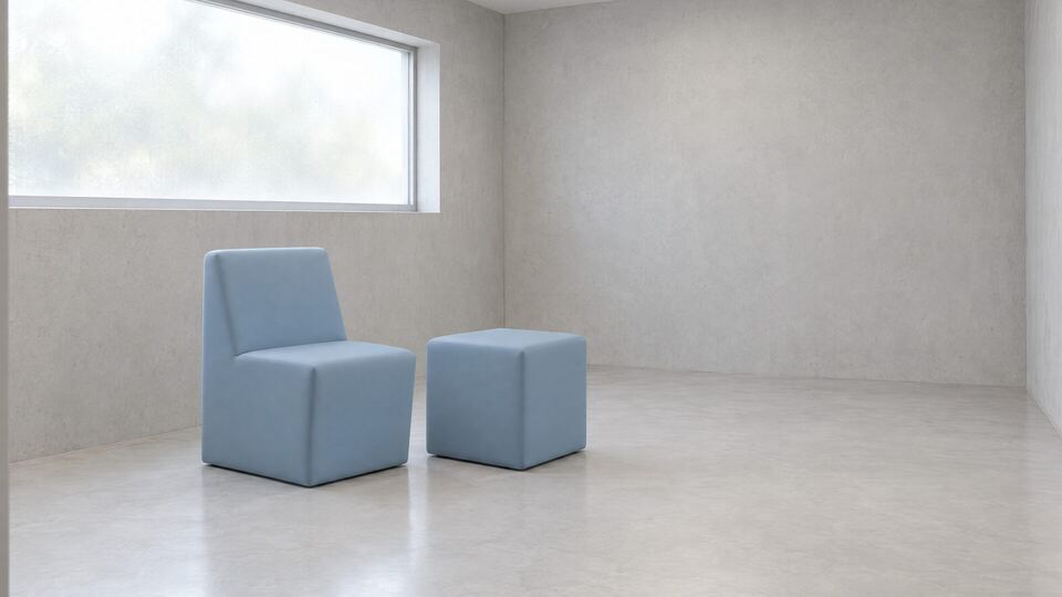 Chaise et cube QMtex® gris-bleu sous la fenêtre d’une salle d’apaisement – QMtex®, région de Malines